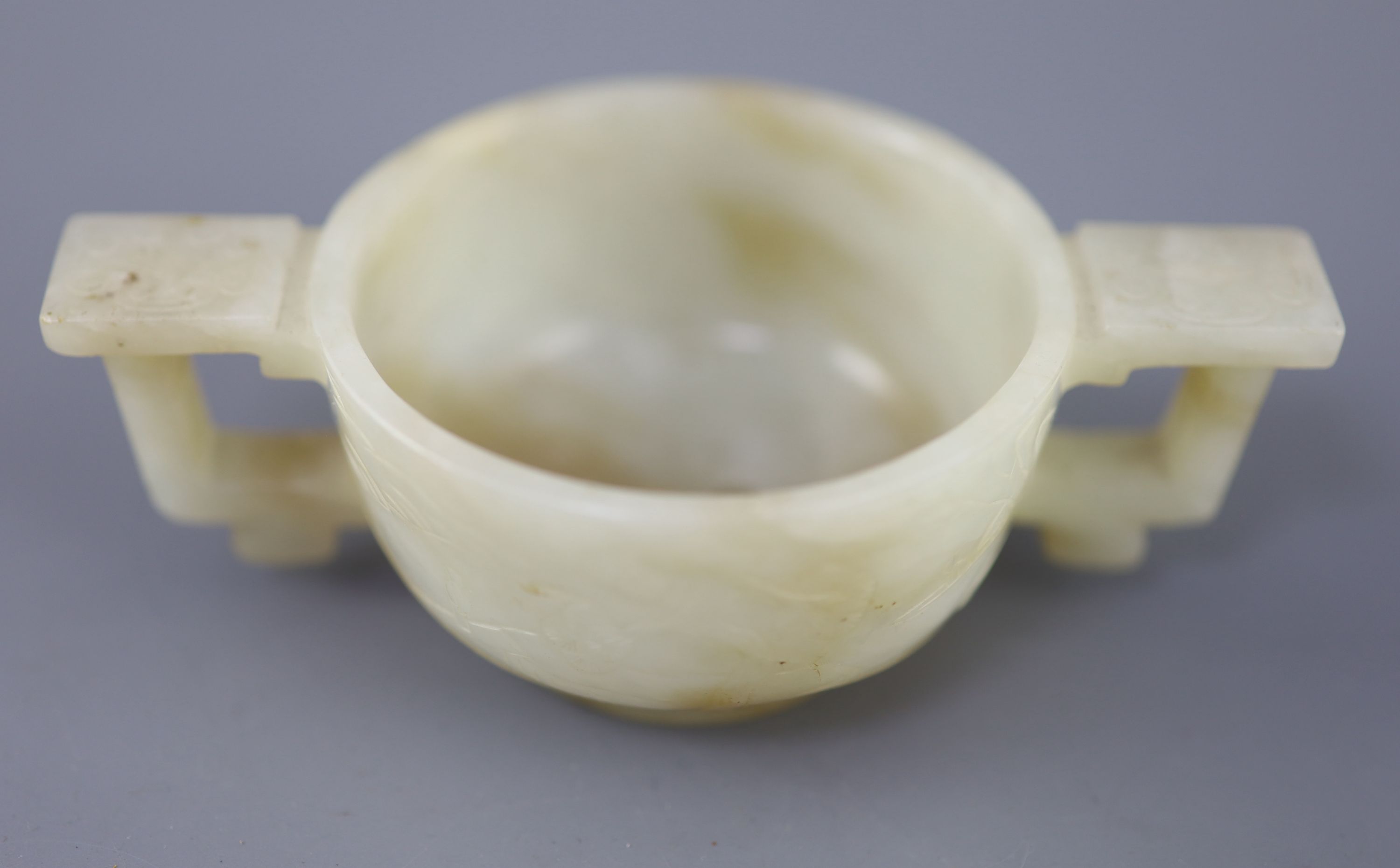 A Chinese pale celadon and russet jade cup, 17th/18th century, 12.5cm wide